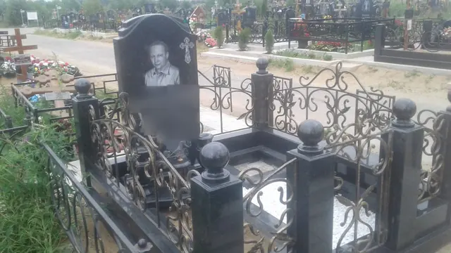 Мемориальный комплекс с фигурной стелой и оградой с золотистым узором