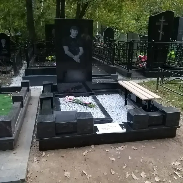 Ступенчатый гранитный цоколь с белой крошкой и деревянной скамьей