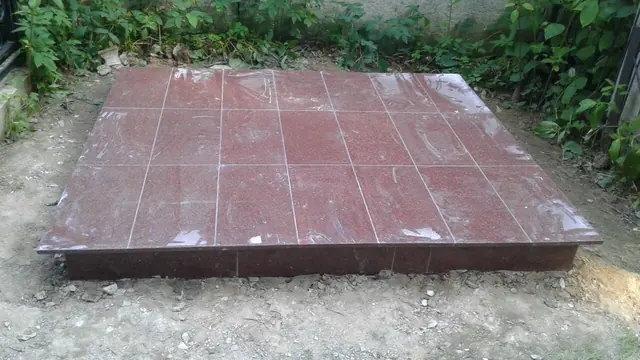 Площадка захоронения с красной плиткой и низким бордюром