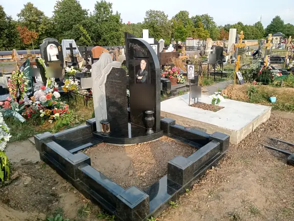 Контрастный памятник из светлого и темного камня с открытым цветником