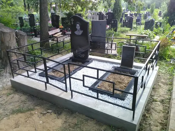 Геометрическая ограда на светлом цоколе вокруг двух памятников