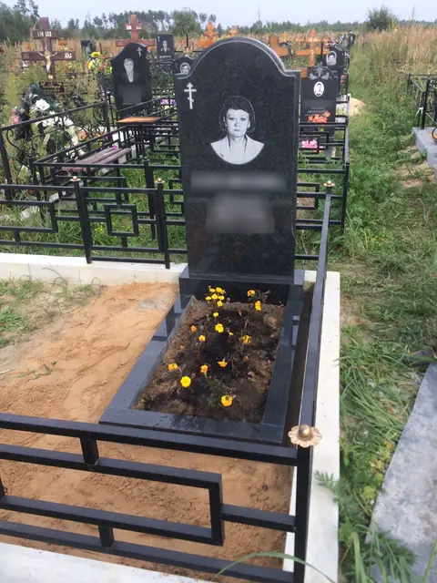 Арочная портретная стела с цветущими растениями в цветнике