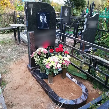 Вертикальный черный памятник с округлым цветником