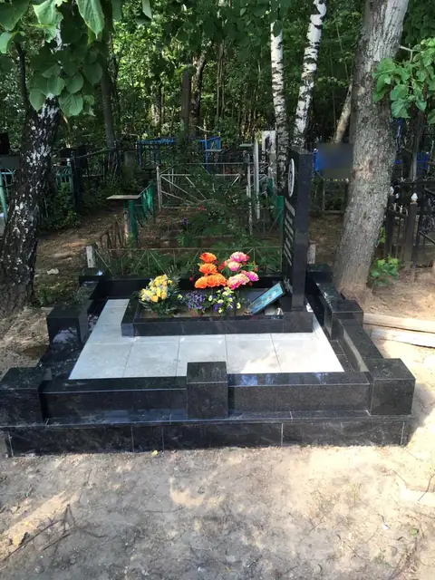 Гранитный цоколь со светлым мощением и открытым цветником