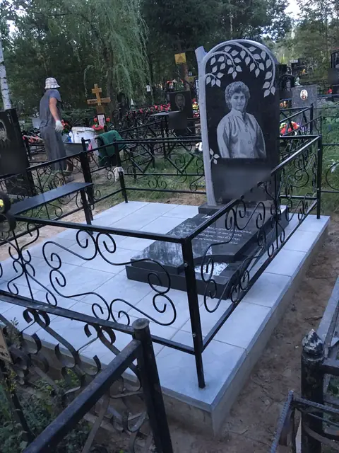 Памятник с резными листьями березы и закрытой надгробной плитой