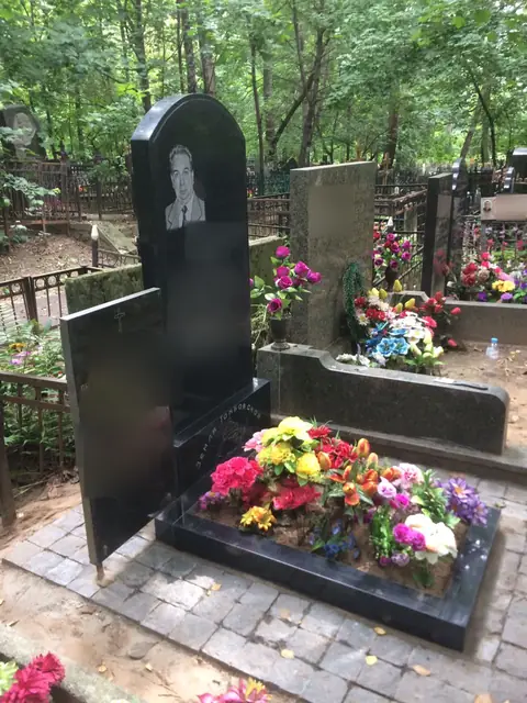 Высокая арочная стела с цветником на лесном участке