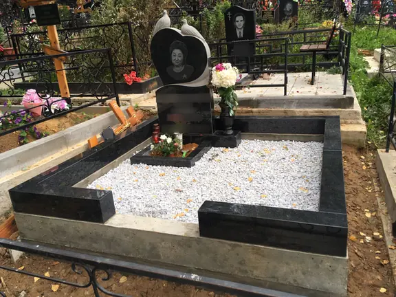 Памятник с круглым портретным медальоном и фигурным светлым краем