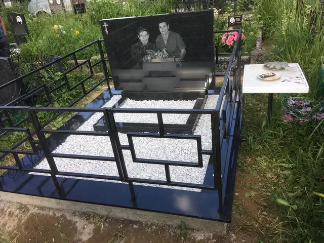 Широкий черный памятник с двумя портретами и белой отсыпкой
