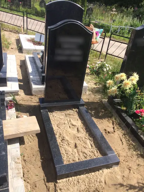 Черная асимметричная стела с дугообразным узором и узким цветником