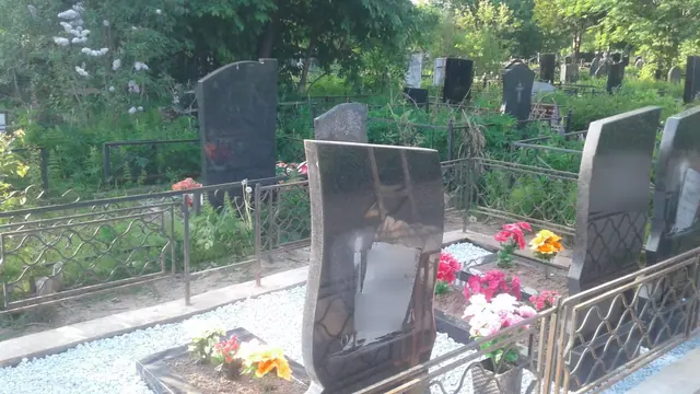 Фигурная стела с портретом и белой каменной крошкой вокруг цветника