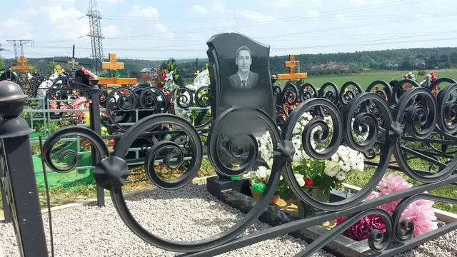 Ограда с крупными завитками вокруг участка с белой каменной крошкой