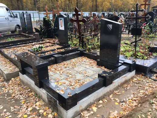 Гранитный цоколь с массивными столбиками вокруг участка