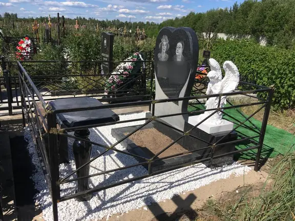 Семейный памятник в форме сердца с белой скульптурой ангела