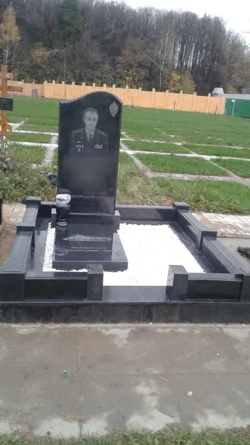 Черная стела с овальным портретом на светлой площадке