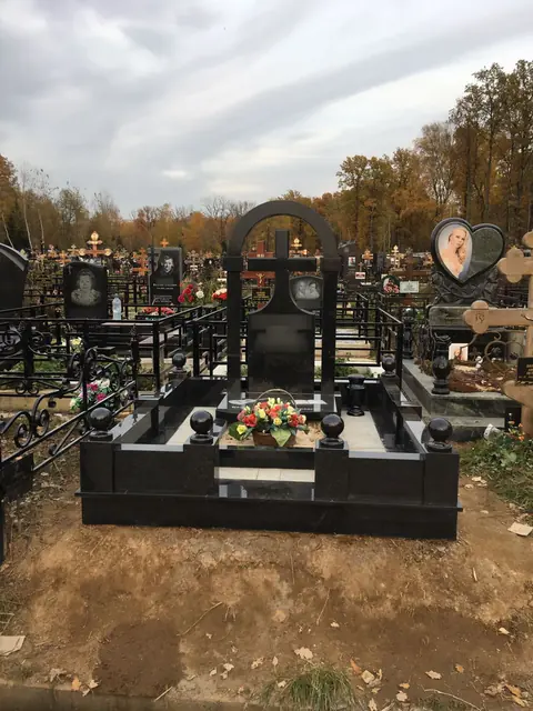 Памятник с аркой и прорезным крестом в гранитном цоколе
