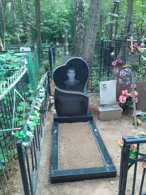 Памятник в форме сердца с портретом и узким цветником