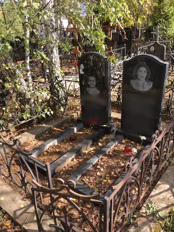 Два портретных памятника с отдельными цветниками под деревьями