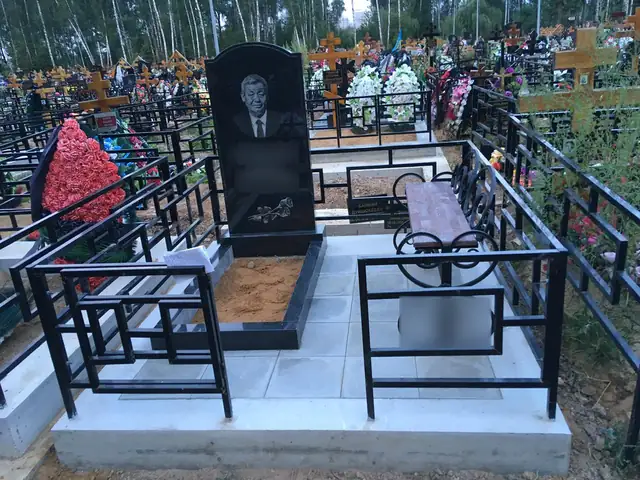Мощёный участок с фигурным памятником и металлическим столиком