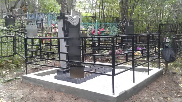 Светлая плитка вокруг памятника с крестом и драпировкой