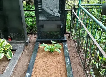 Овальный черный памятник с поясным портретом и цветником