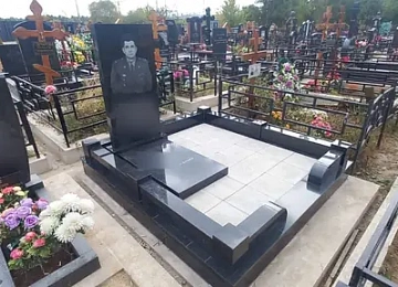 Прямоугольный памятник с надгробной плитой на мощёном участке