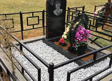 Арочный портретный памятник на белой крошке за строгой оградой