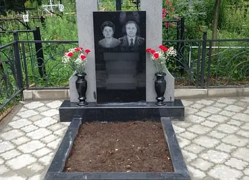 Памятник с центральным крестом, светлыми боковыми частями и цветником