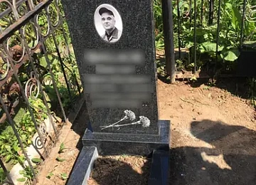 Строгий черный памятник с овальным медальоном и узким цветником