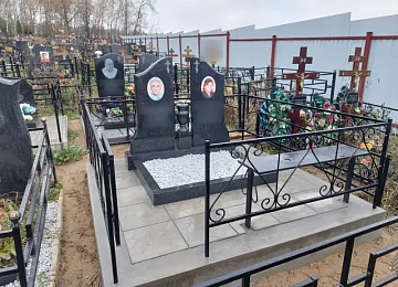 Две черные арочные стелы на белой крошке за кованой оградой