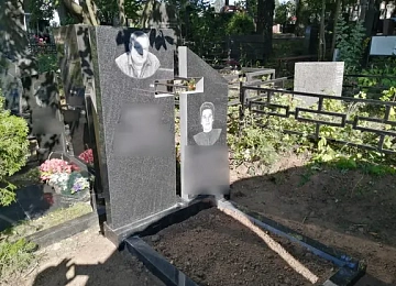 Двойной памятник из светлого камня с разновысокими стелами