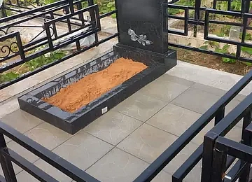 Вертикальный памятник с длинным цветником на мощёном участке