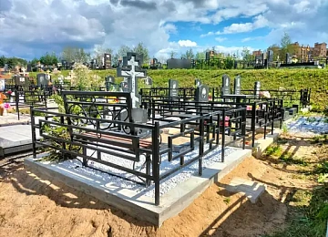 Серый крест на белой крошке внутри геометрической ограды