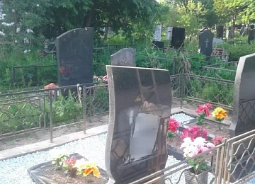 Фигурная стела с портретом и белой каменной крошкой вокруг цветника