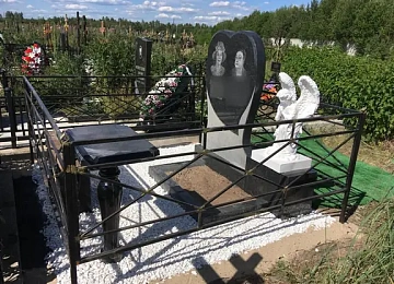 Семейный памятник в форме сердца с белой скульптурой ангела