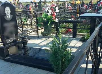 Чёрная стела с крестом и вазами на светлой плитке