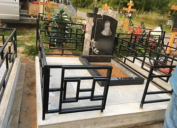 Резная берёза на чёрном памятнике с мощёным участком