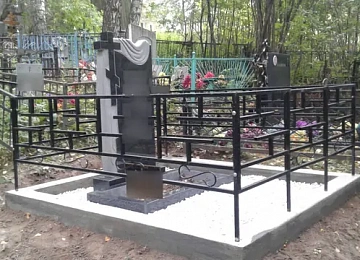 Светлая плитка вокруг памятника с крестом и драпировкой